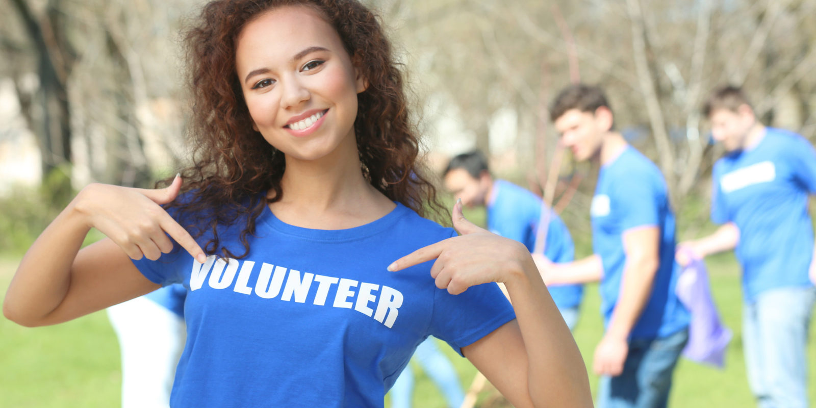 A smiling volunteer in a community, representing local support and resources